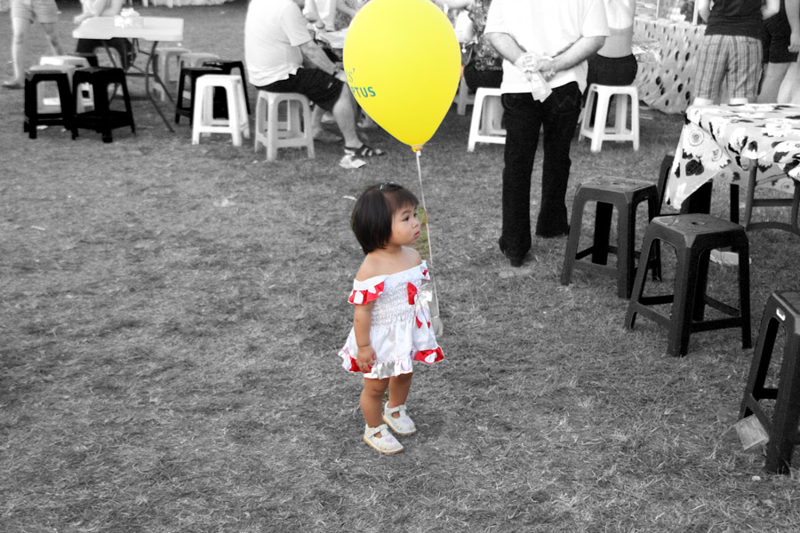 99 - Little girl at Tet function with yellow balloon.